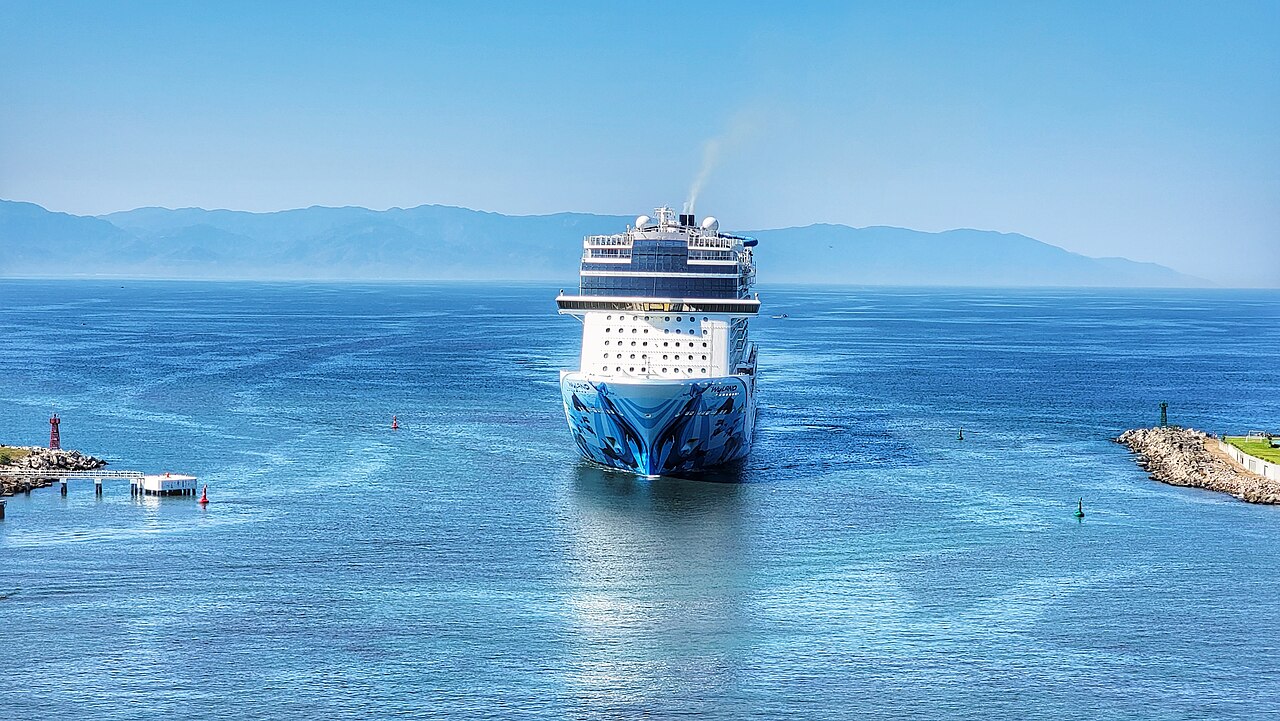 A cruise ship approaching a harbour entrance.
