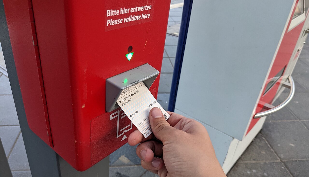 Vasúti jegy érvényesítése egy jegykezelő gépnél.