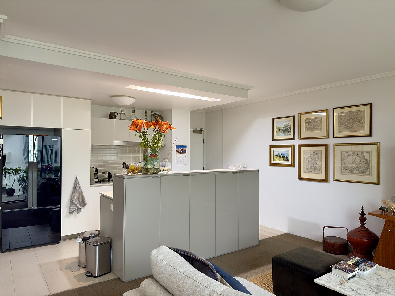 An apartment kitchen with cupboards and a dining surface.