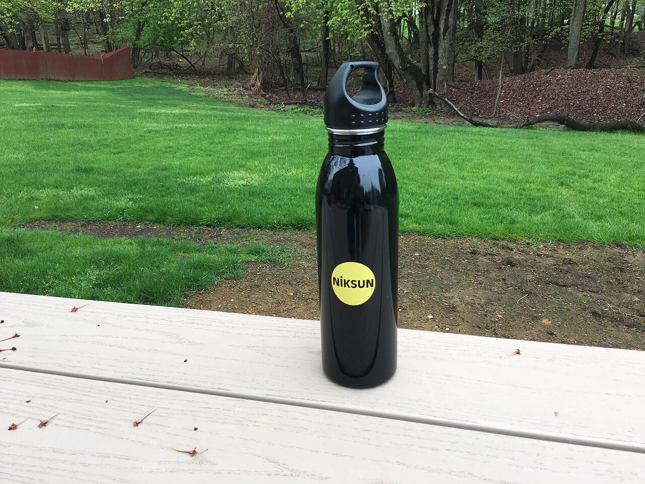 A reusable metal water bottle on an outdoor table.