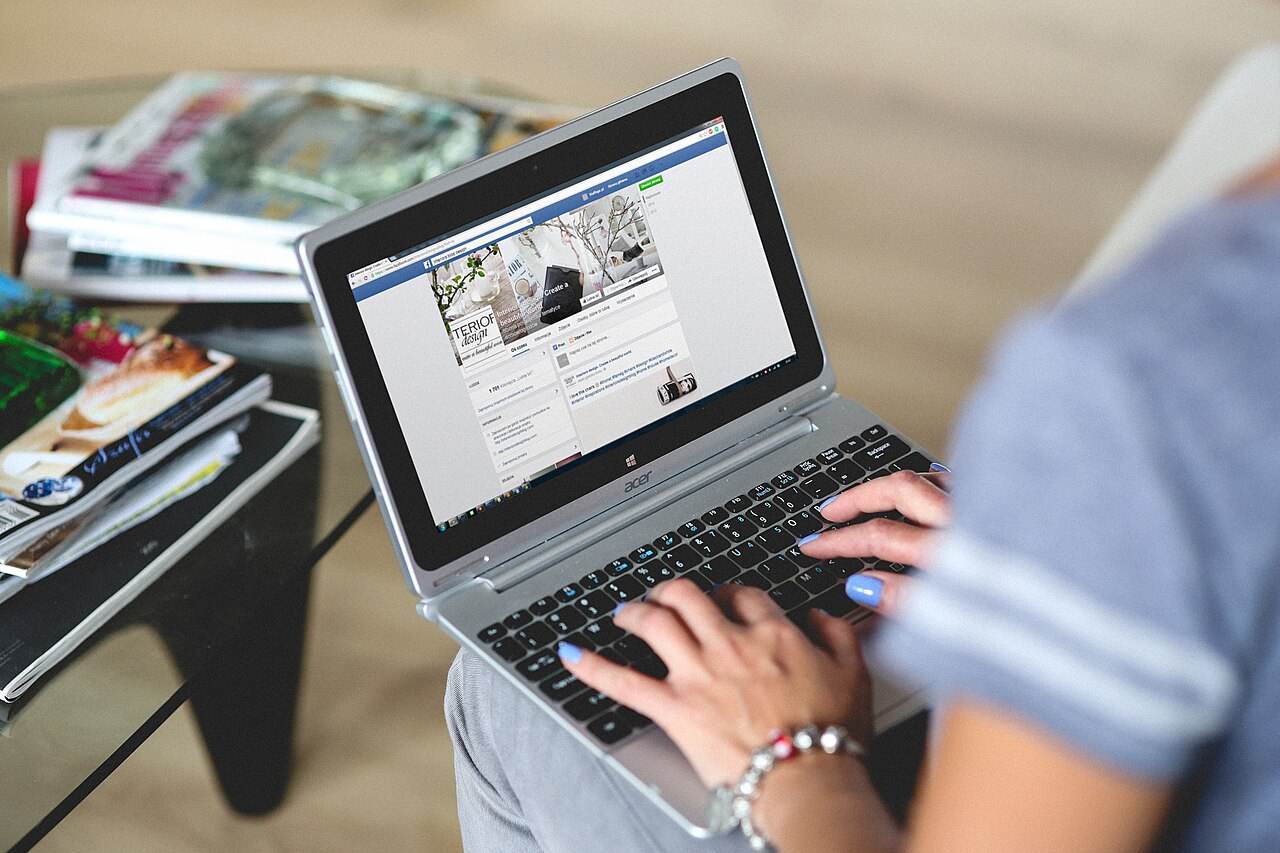 A person working on a laptop while seated.