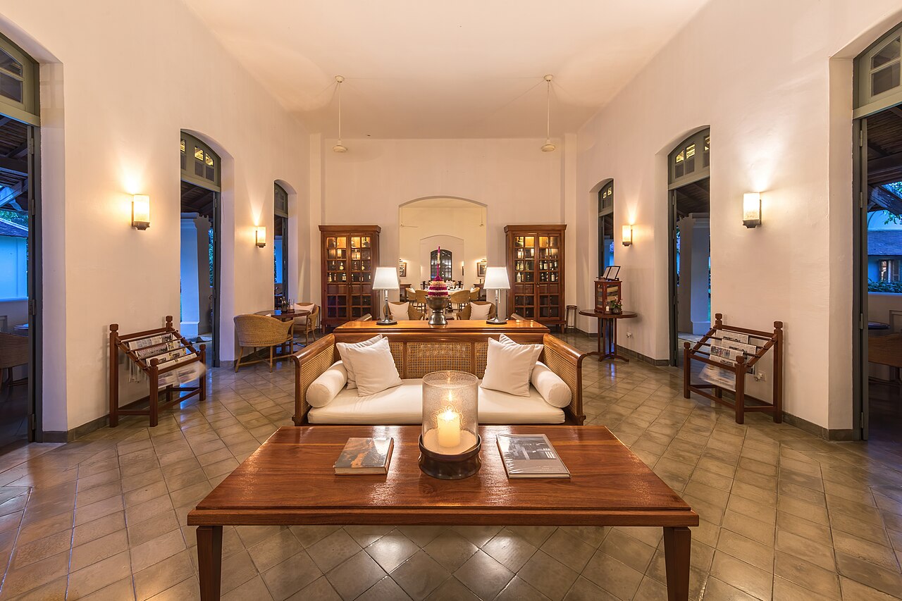 A bright hotel lounge with a wooden table and seating.