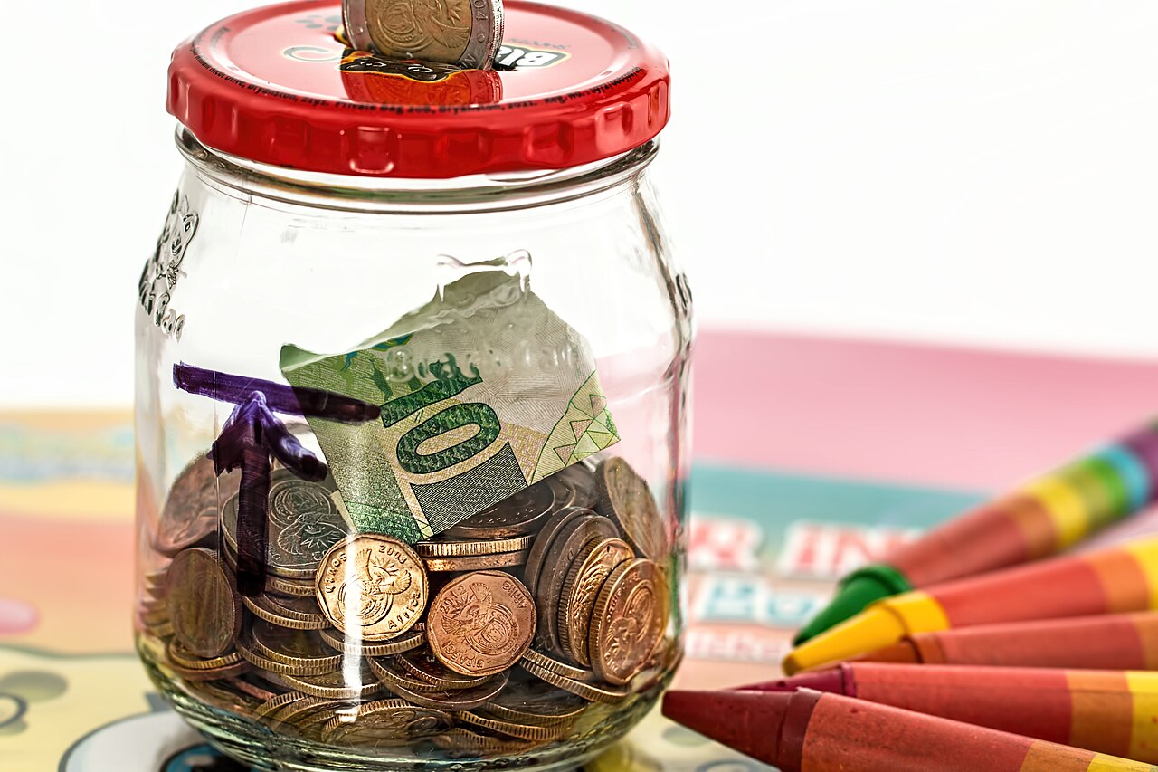 A savings jar containing coins and banknotes.