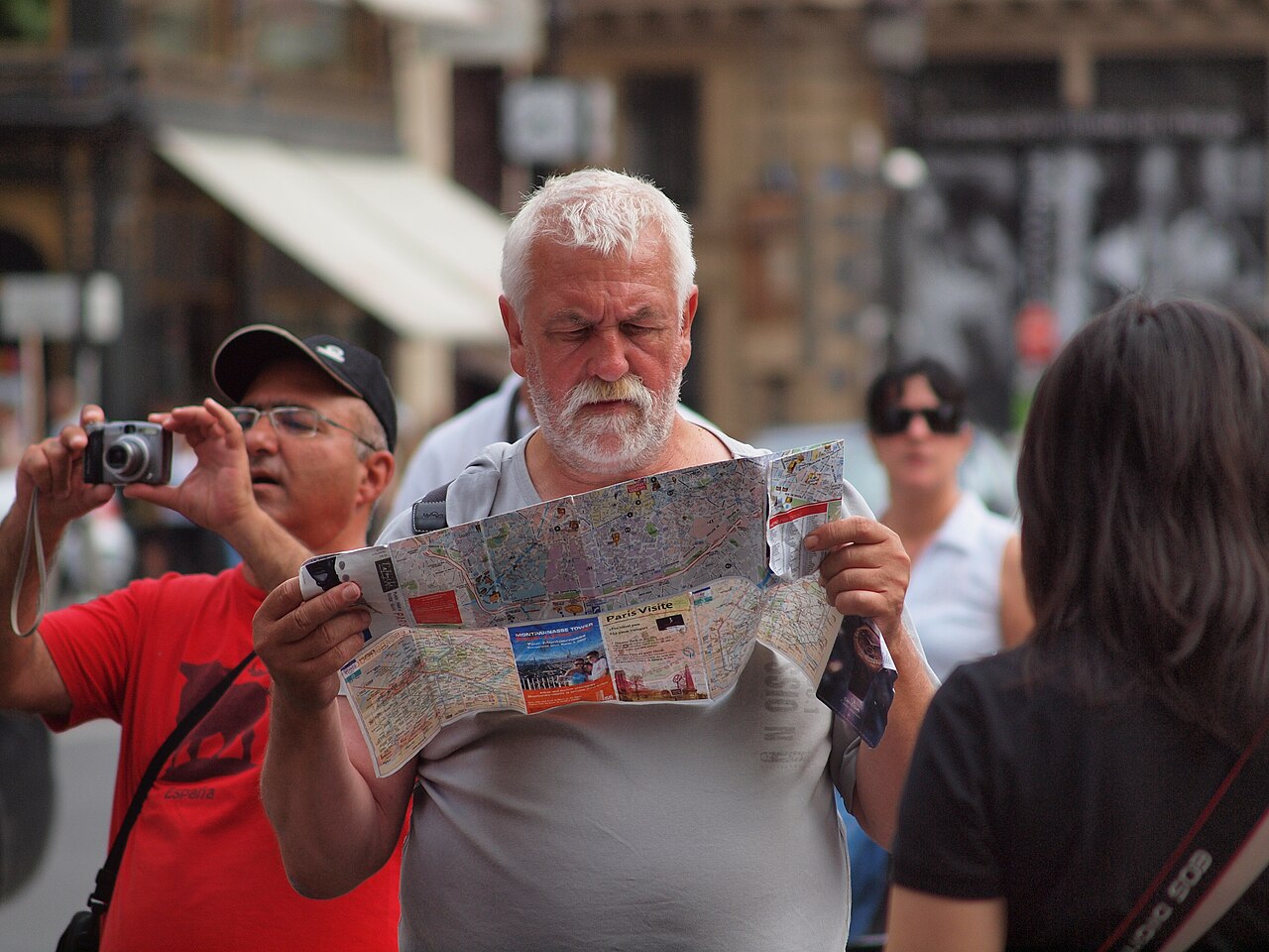 A traveller reading a city map on a Paris street.