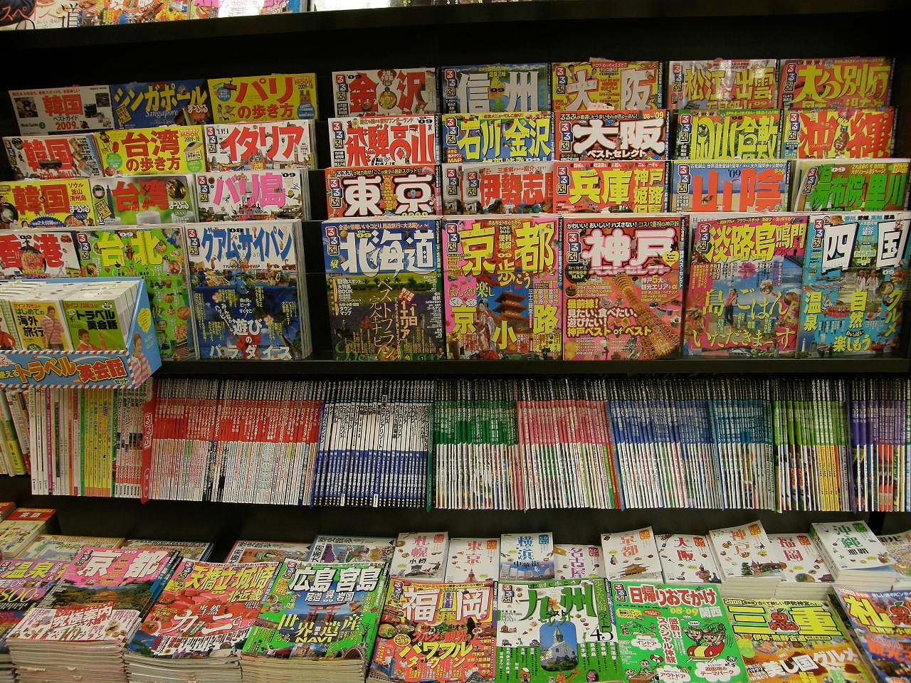 A bookshop shelf filled with travel guidebooks.